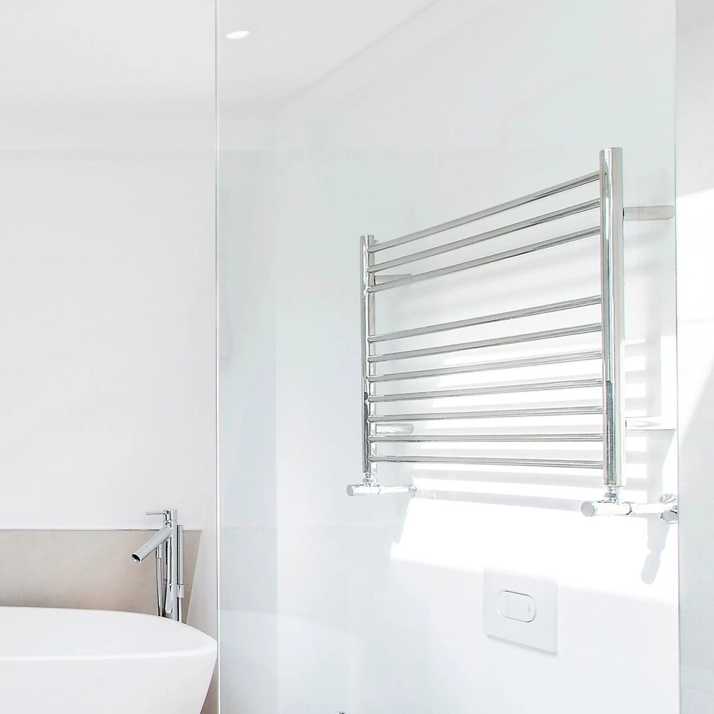 Lifestyle image of the The Sussex Range by JIS Newick 600mm x 1200mm Polished Stainless Steel Heated Towel Rail installed on a white bathroom wall